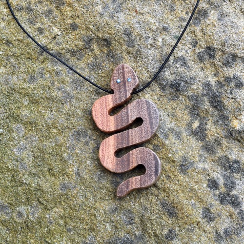 Handmade wooden snake pendant set with sapphire eyes by Treetop Trove